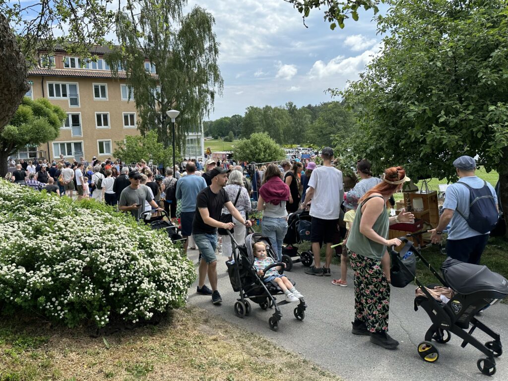 Människor trängs framför loppisbord.